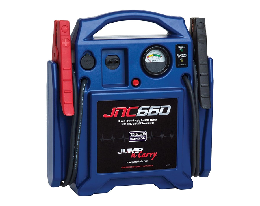 A bulky jump starter with a carry handle, a dial gauge, several sockets and heavy clamp leads.